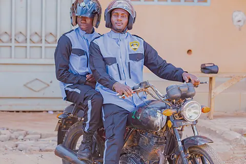 Deux agents casqués sur une moto de patrouille.